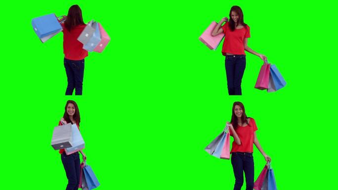 一个亚洲女性拎着购物袋跳舞在绿色背景下