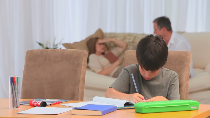 小男孩放学后在客厅里做作业