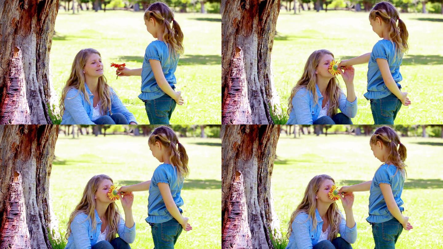 女孩在公园里给她妈妈一朵花
