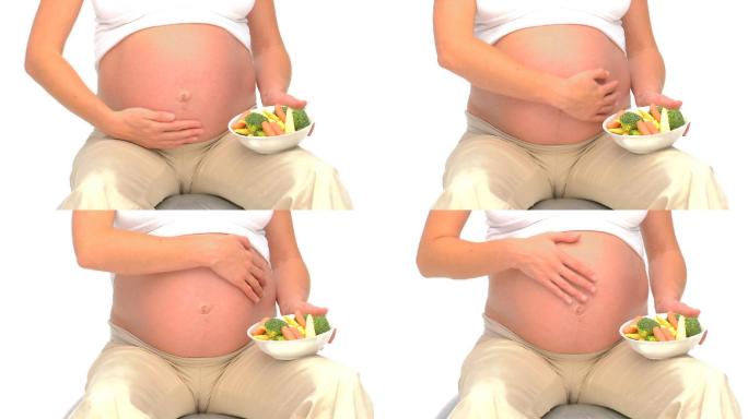 孕妇抱着蔬菜营养餐备孕大肚子