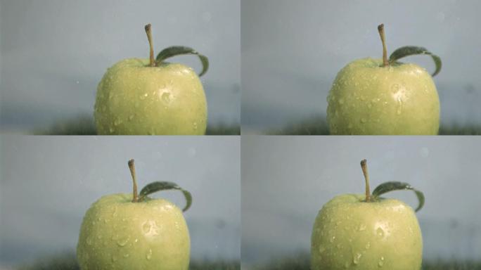 水滴落在青苹果上慢镜头，在灰色背景下