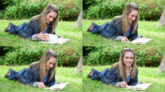 一个白人金发少女趴在草地看书