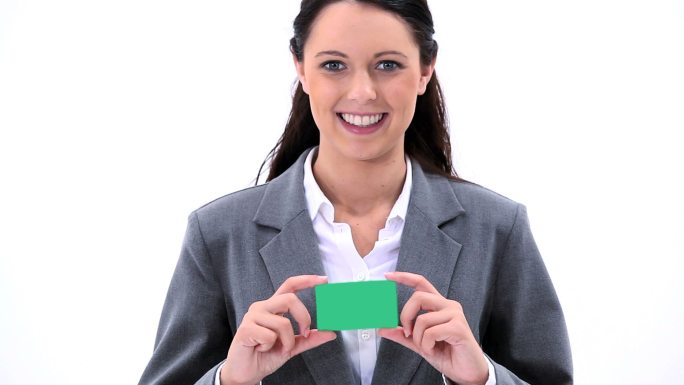 一个黑发女性拿着一张绿色卡片，在白色背景下