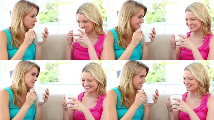 两个金发女人坐在沙发上喝咖啡