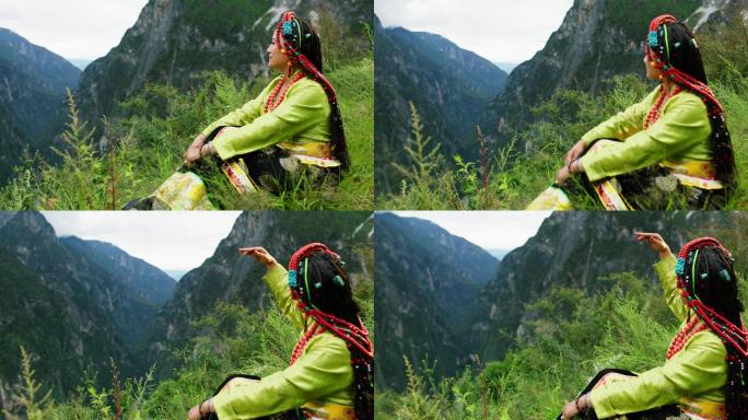 藏族女子坐在草地上欣赏高山风景