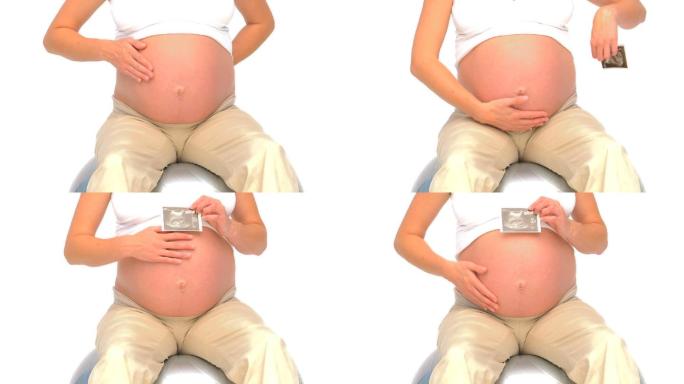 一名怀孕女性在健身球上拿着她未来宝宝的扫描图