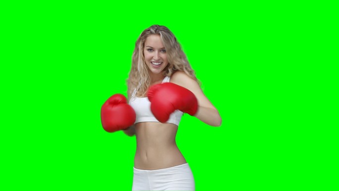 一个在绿色背景下拳击的女人
