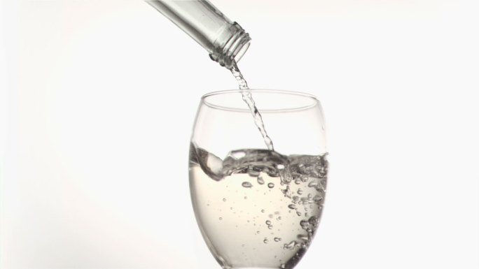 白葡萄酒在白色背景下以超慢的动作从瓶中落下