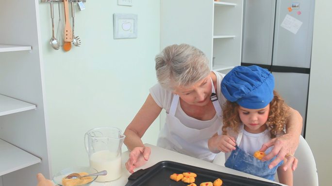 奶奶和她的孙女正在品尝他们刚做的饼干