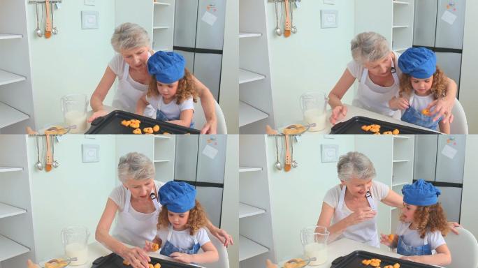 奶奶和她的孙女正在品尝他们刚做的饼干
