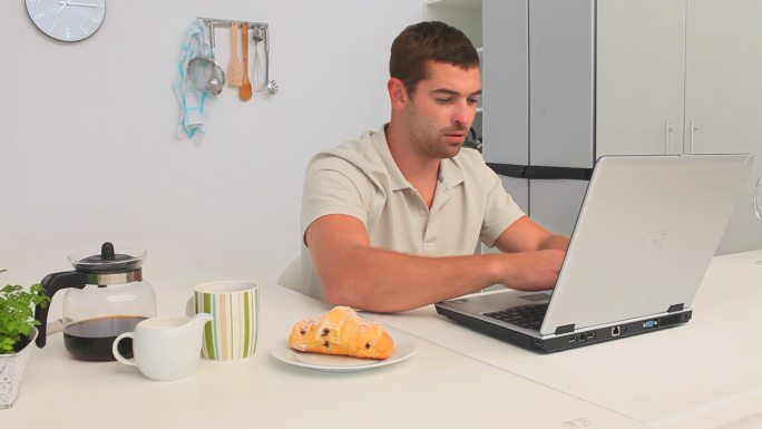 一个普通人在厨房里用笔记本电脑工作