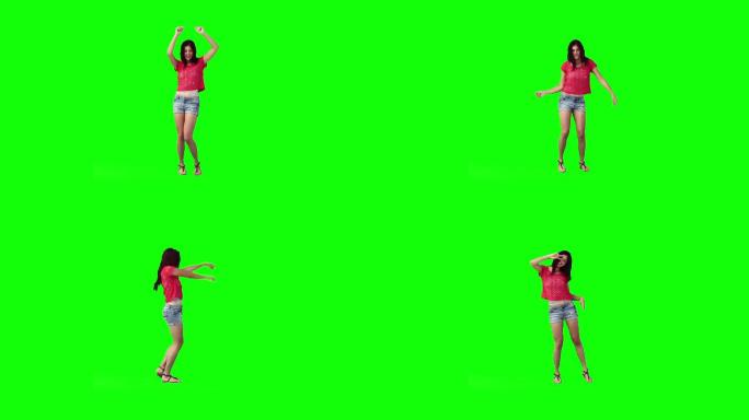 一个年轻女子在绿色的背景下跳舞