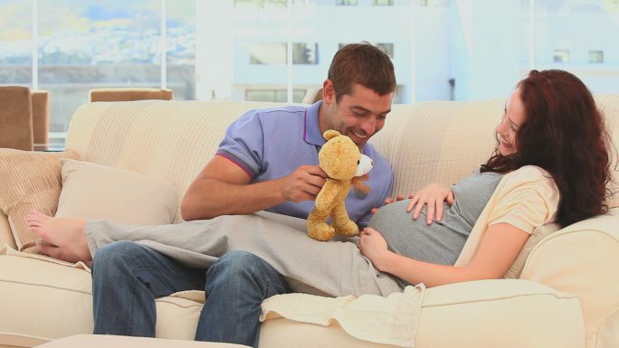 未来的父母在客厅里玩泰迪熊