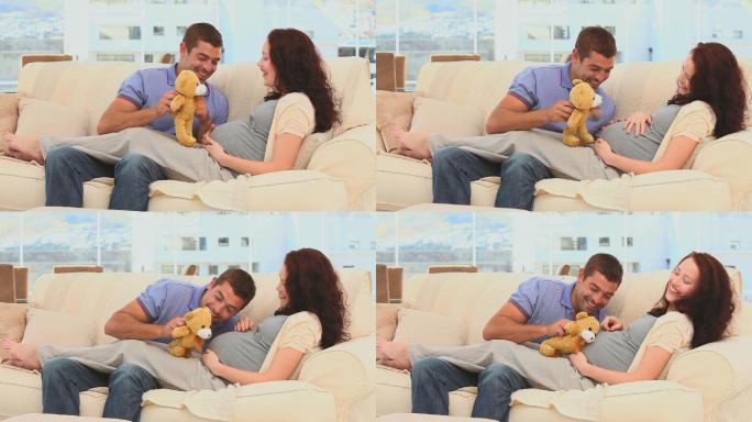 未来的父母在客厅里玩泰迪熊