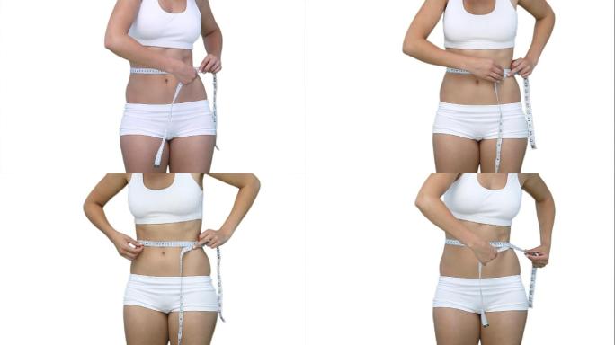 一个女人的近距离使用测量磁带在她的腰部对白色的背景