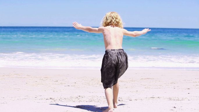 金发小孩在沙滩上做倒立