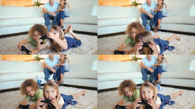孩子们在地毯上玩电子游戏，而他们的父母在观看