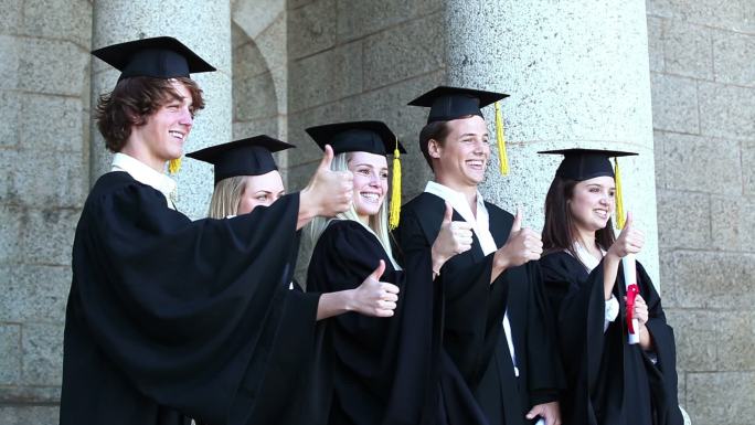 五个身着毕业礼服的青年做手势