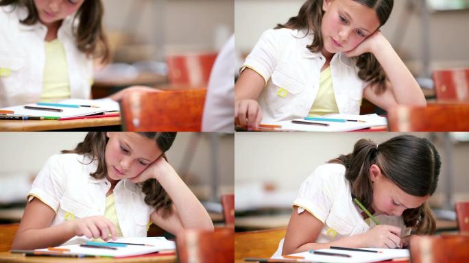 小女孩在教室里写笔记本