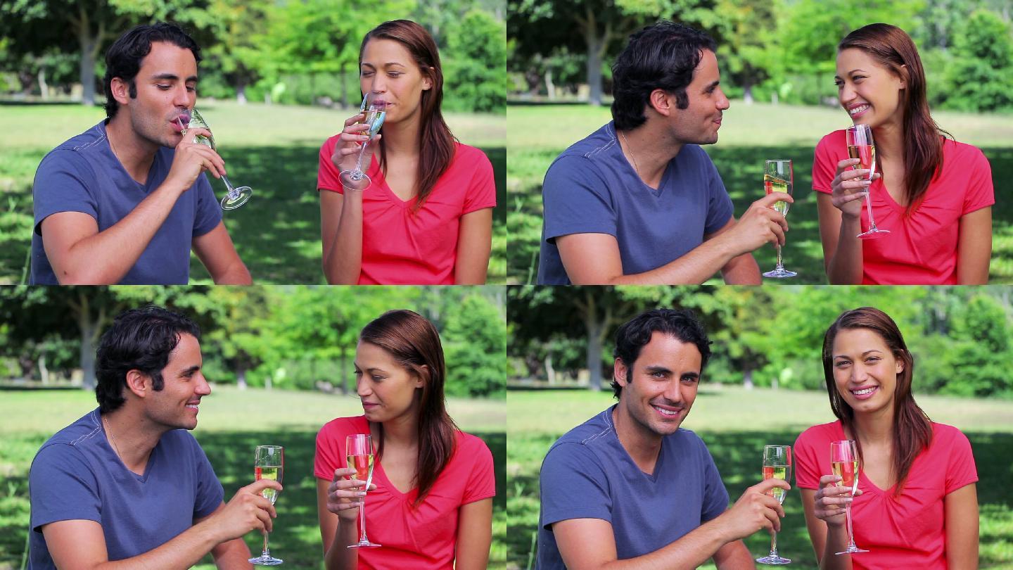 幸福的夫妇在乡下碰杯喝香槟