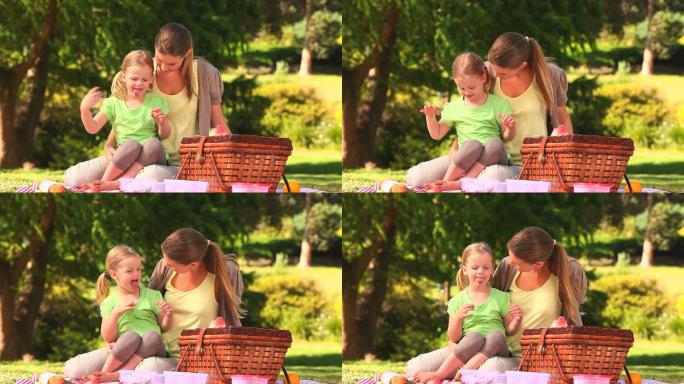 妈妈和她的女儿在公园野餐吃西瓜