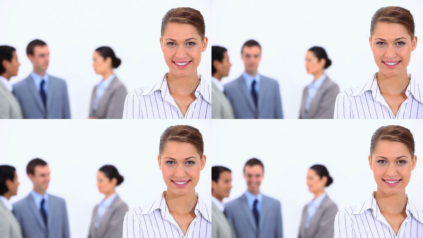 女商人看着相机和同事在一个白色的背景