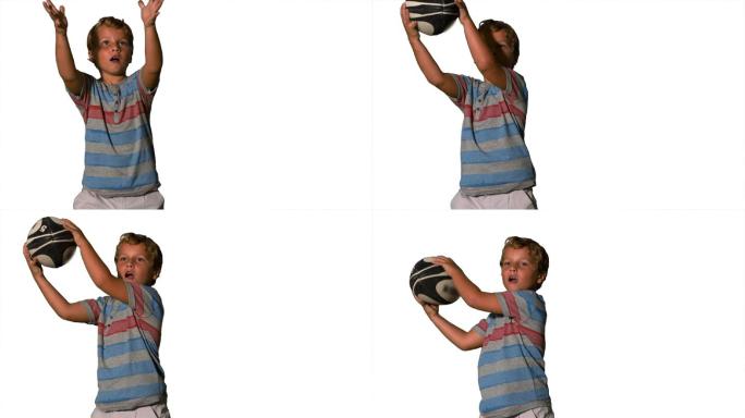 在慢镜头中，白色背景上的小男孩正在抓着橄榄球