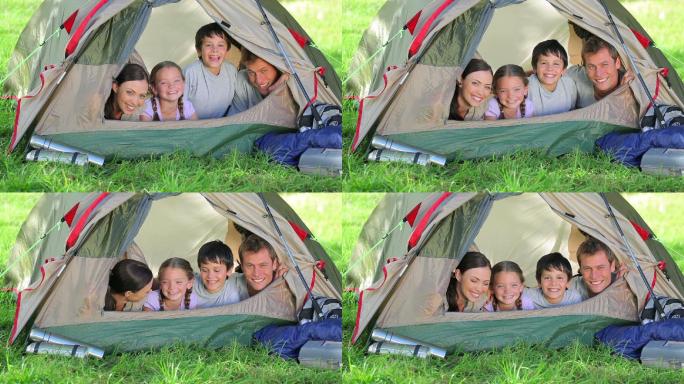 一家人微笑着躺在乡村的一个帐篷里