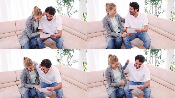 一个年轻人和他的女朋友在客厅里读一封信