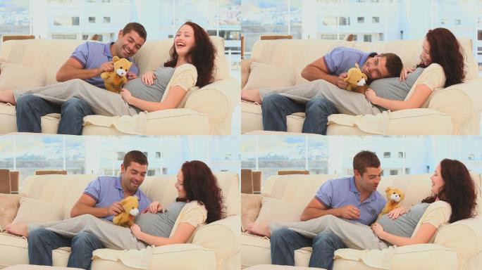 一对可爱的夫妇在沙发上玩泰迪熊