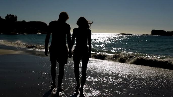 放松的情侣站在月光下的海滩上