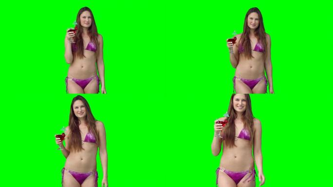 在绿色的背景下，一个穿着泳衣的女人拿着饮料走上前