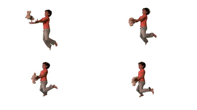 一个黑人男孩跳跃接毛绒玩具慢镜头，在白色背景下