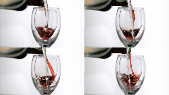 在白色背景下，以超慢动作填充酒杯的葡萄酒