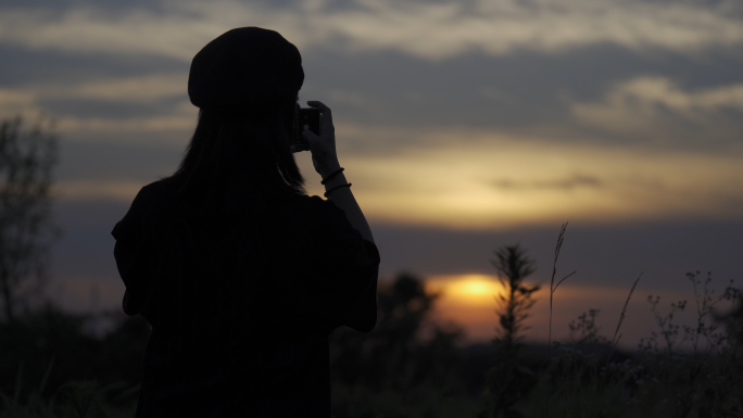 女孩背影手机拍照夕阳