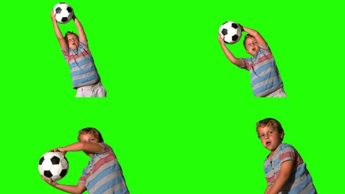 一个男孩在绿色屏幕上用慢镜头接住了足球