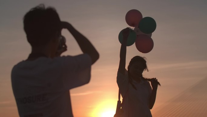 夕阳日落海边情侣拍照