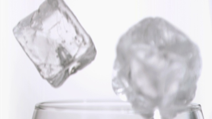 冰块落入玻璃杯慢镜头，在白色背景下