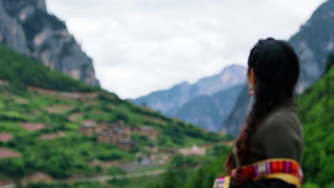 藏族女子凝望古村落