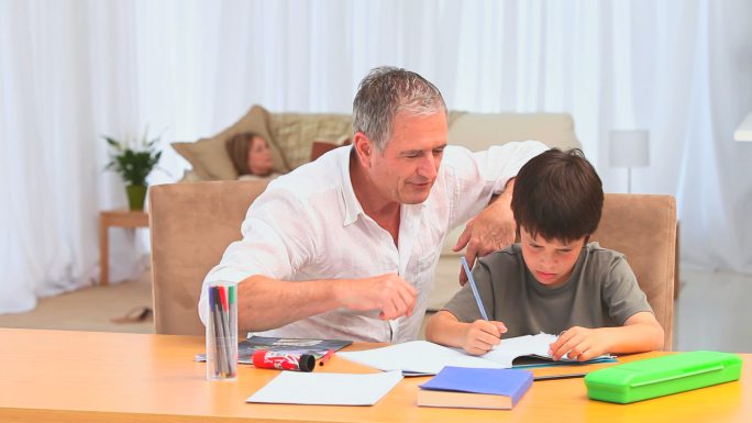 小黑头发男孩放学后在客厅做作业