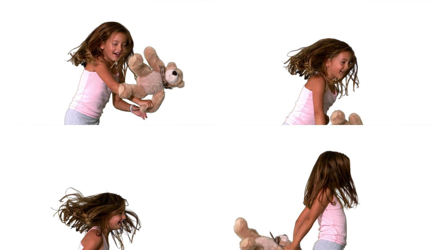 小女孩跳上跳下和旋转与泰迪熊在白色的背景慢动作