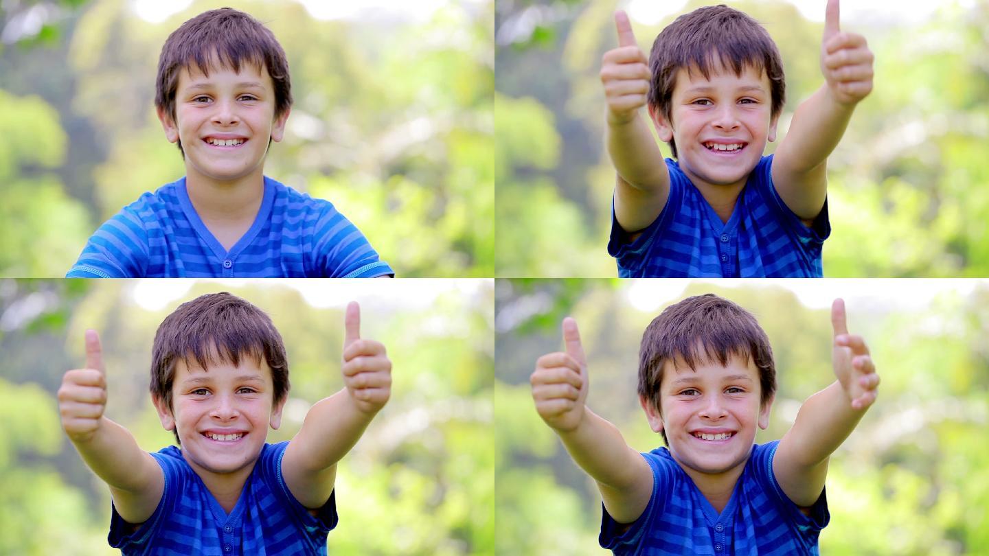 微笑的孩子在公园里竖起大拇指