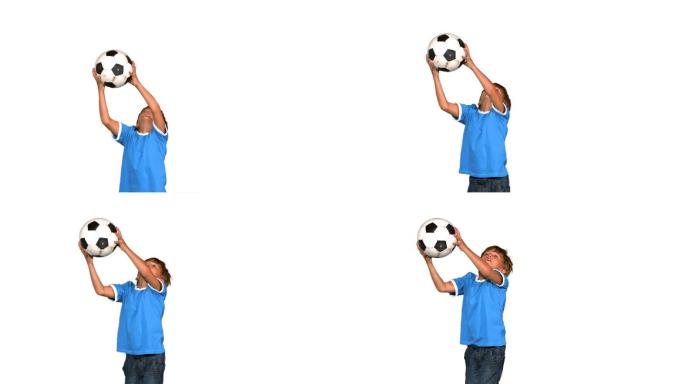 一个西方男孩跳跃接足球慢镜头，在白色背景下