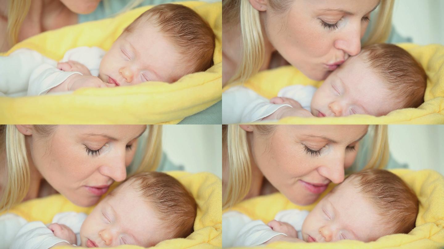 一个母亲亲吻熟睡的婴儿的特写