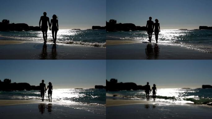 一对可爱的情侣在月光下漫步在海滩上