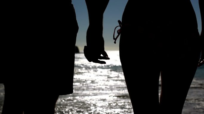 一对情侣在月光下漫步在沙滩上