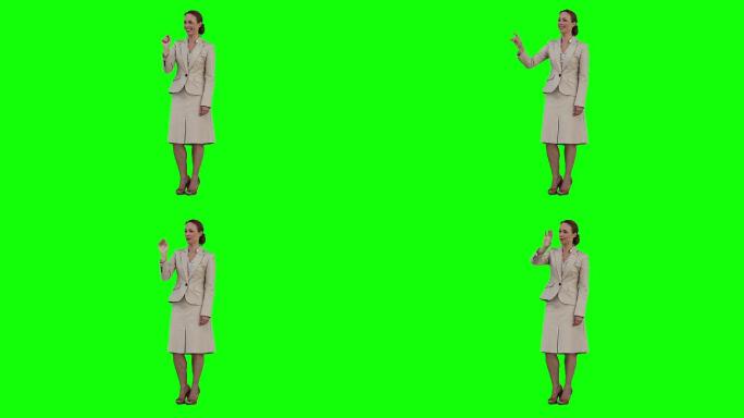 一位女士正在绿色背景前使用虚拟触摸屏