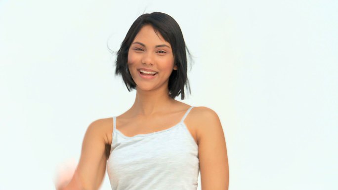 快乐的亚洲女人看着相机在一个白色的背景