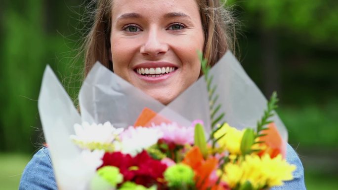 一个白人女人面带微笑举着花束