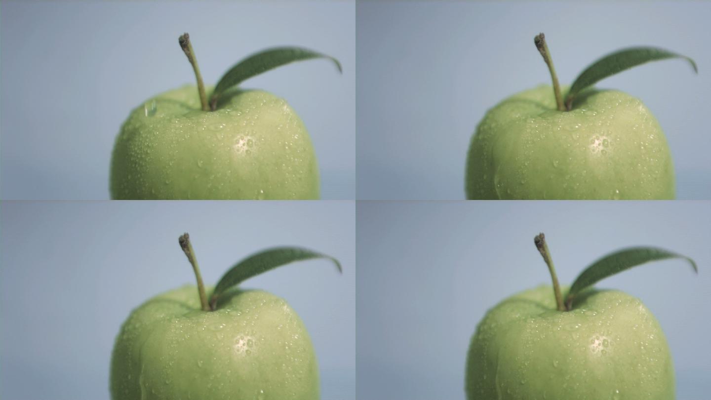 一滴水落在青苹果上，在灰色背景下